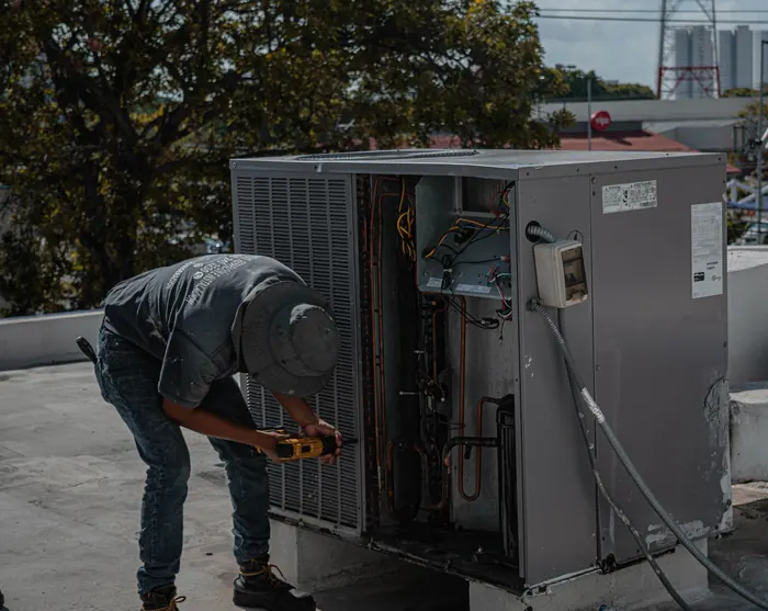 Tesla Cure AC maintenance technician servicing rooftop unit in Dubai